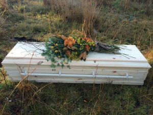 An image of simple pine box coffin